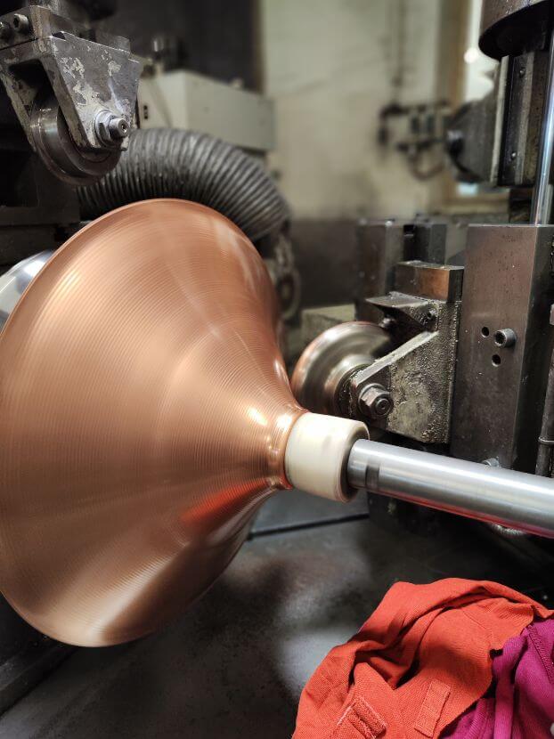 metal spinning process at a CNC machine with a copper material