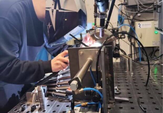 Anton is welding metal with a robot